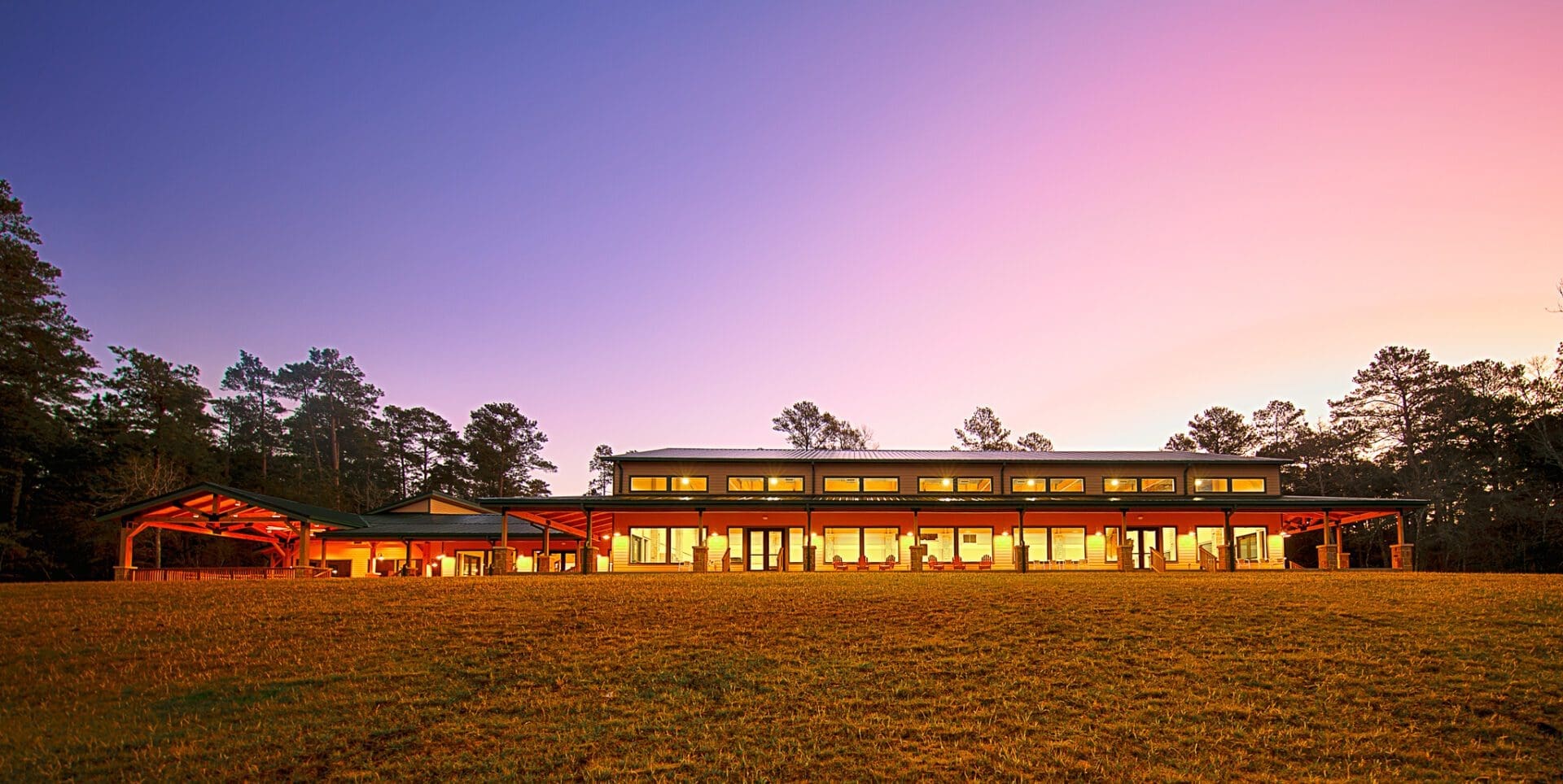 Modern building at sunset with glowing lights.