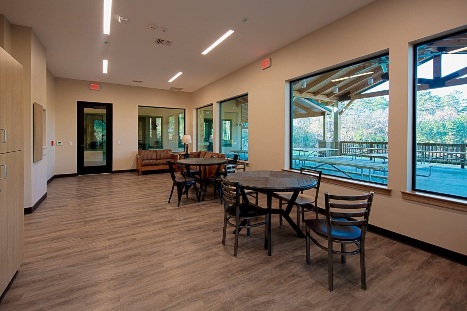 Room with tables and large windows.