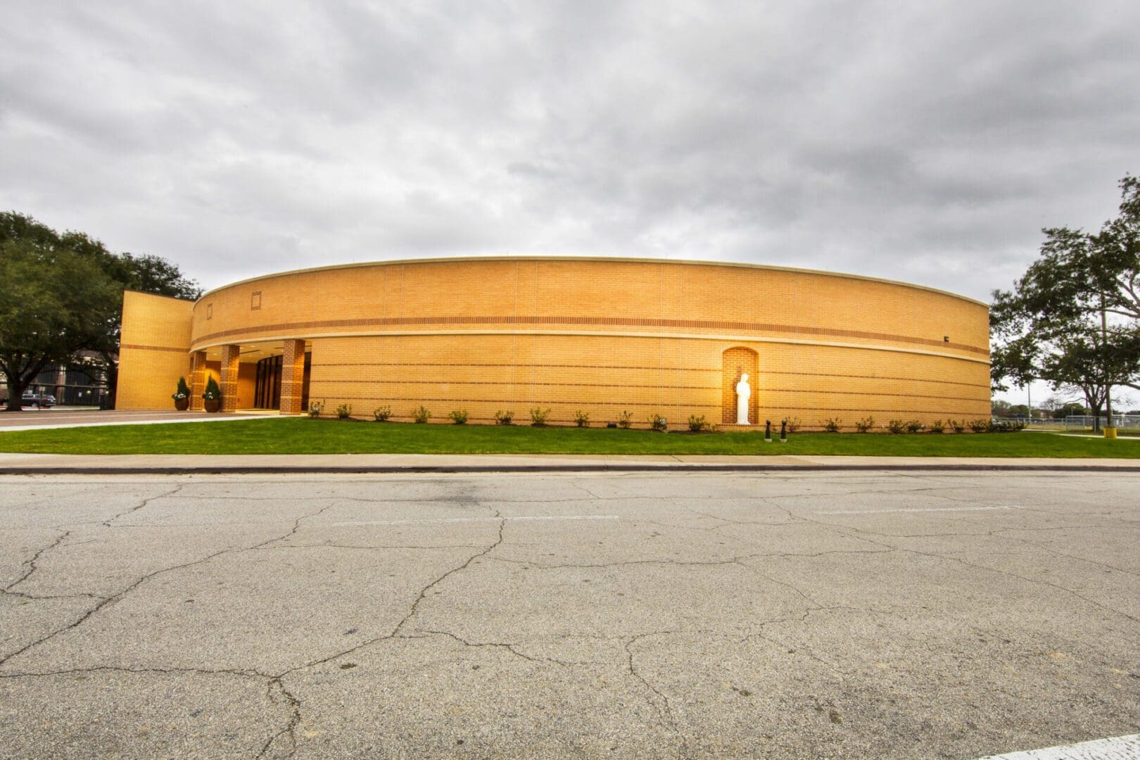 Round building with cloudy sky background.