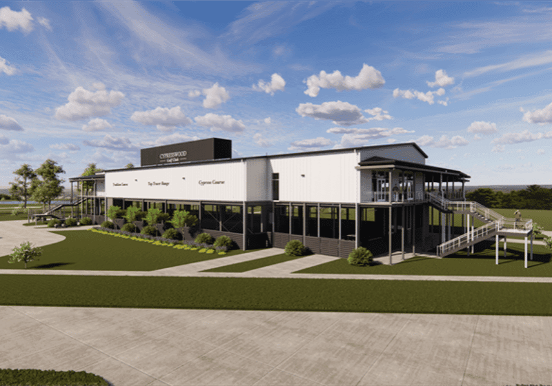 Modern building with large windows and greenery.